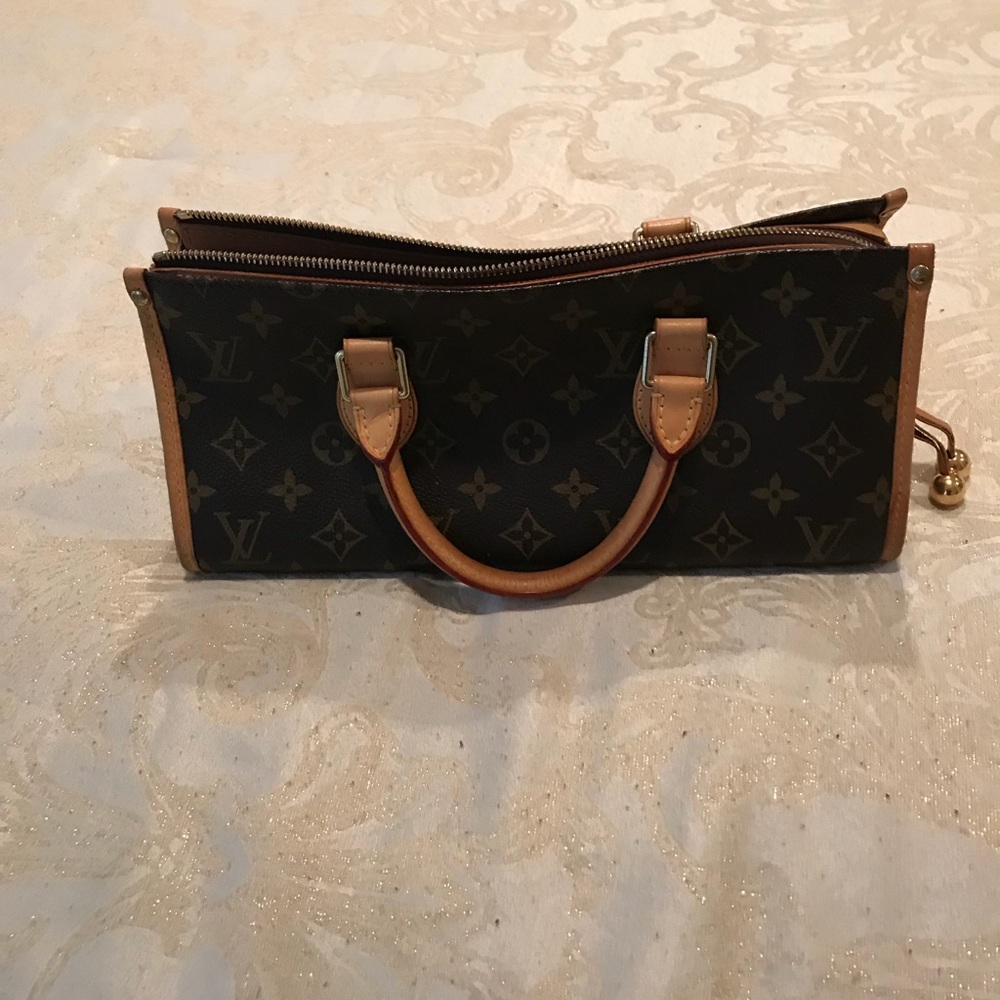 Triangle top handle Louis Vuitton bag.
